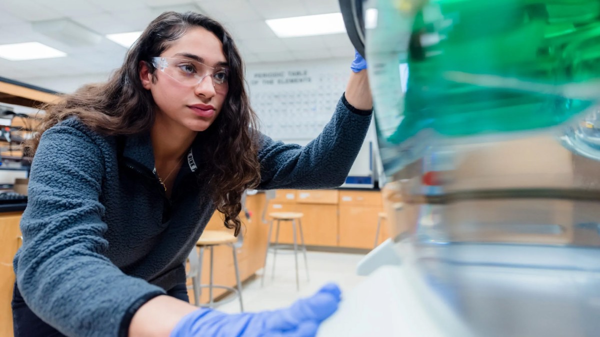 A female student wearing a blue fleece and safety glasses conducts a lab activity in the chemical technology program at Cape Fear Community College in North Carolina.
