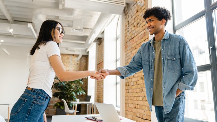 Two organizational leaders shake hands.