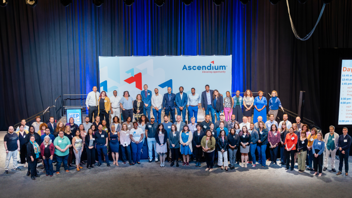 A large group of attendees standing in front of an Ascendium backdrop at the inaugural HEP Grantee Convening.