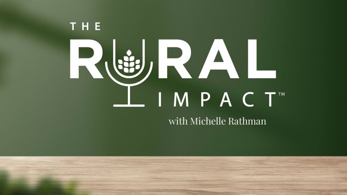 The Rural Impact with Michelle Rathman logo hovers above a calming forest green background set on a wooden foundation, with a tree barely visible in the bottom left corner.