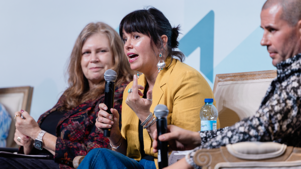 Dr. Erin Castro speaks into a microphone during a session at the HEP Grantee Convening.