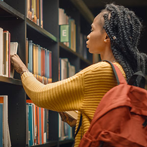 Black female student at a bookshelf